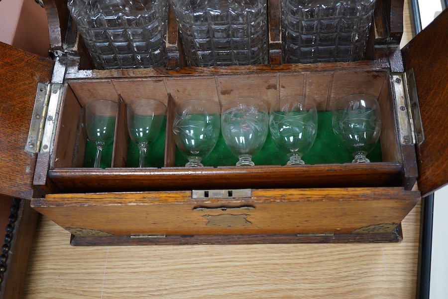 A Victorian oak three-bottle tantalus, with compartment for glasses, 30cm high x 34cm wide